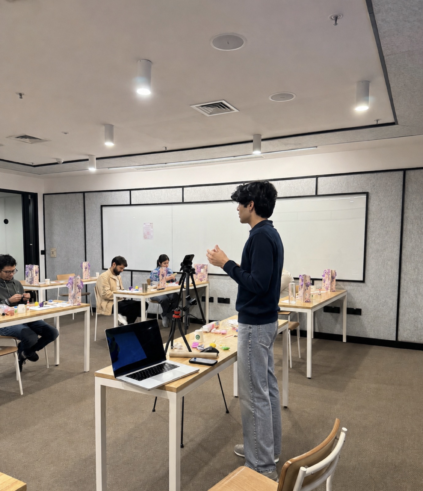 Dhairya Nagpal teaching a clay workshop to a room of participants at their tables